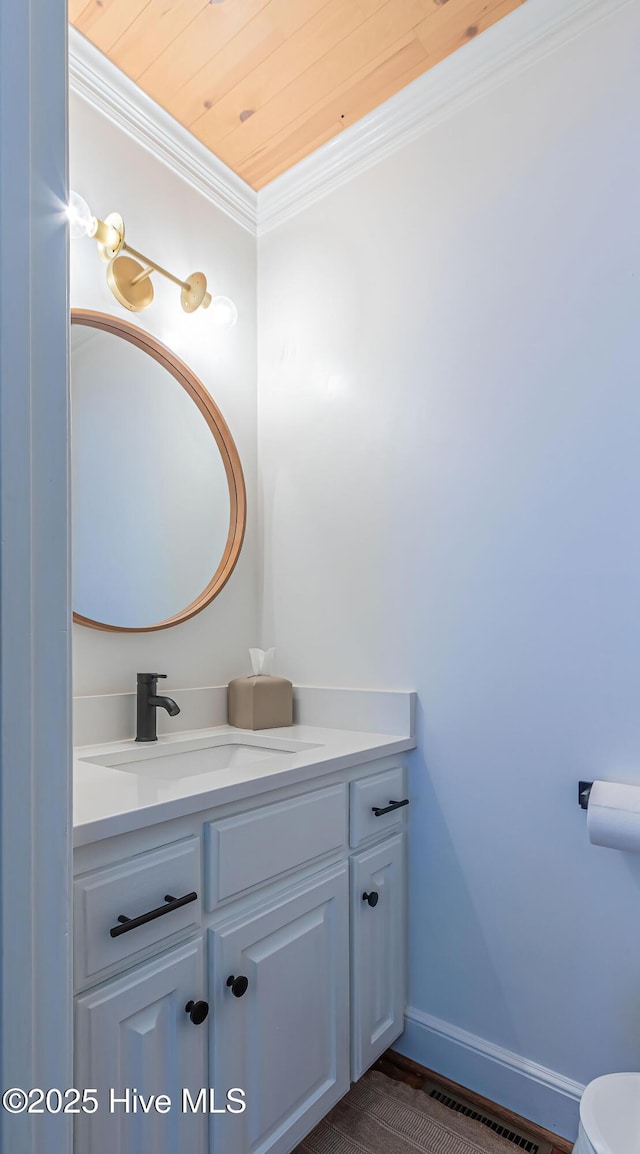 half bath with toilet, crown molding, baseboards, wood ceiling, and vanity
