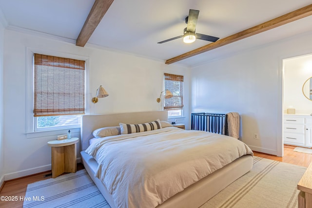 bedroom with beam ceiling, multiple windows, light wood-type flooring, and baseboards