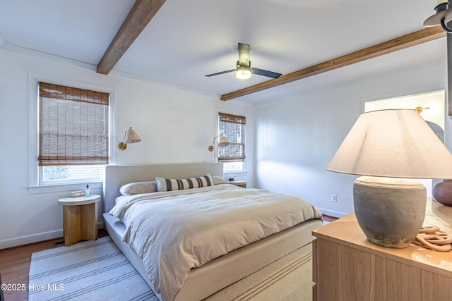 bedroom featuring beam ceiling, ceiling fan, baseboards, and wood finished floors