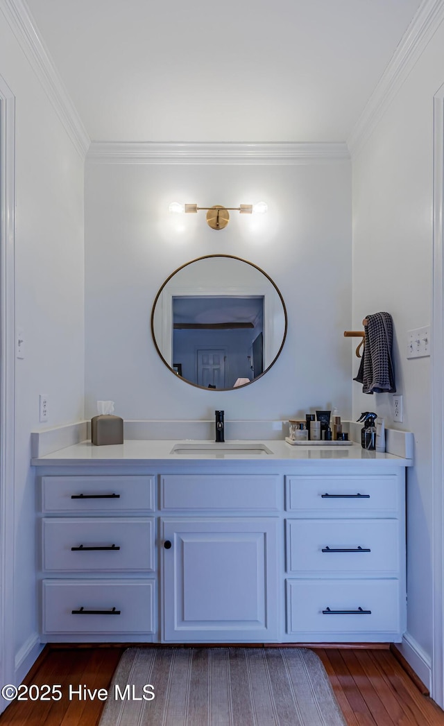 bathroom with vanity, wood finished floors, and ornamental molding