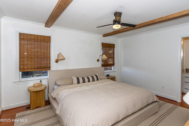 bedroom with beamed ceiling, baseboards, wood finished floors, and crown molding