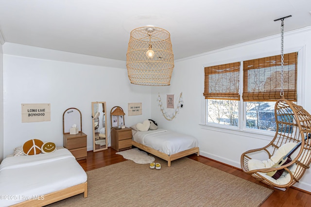 bedroom with baseboards and wood finished floors