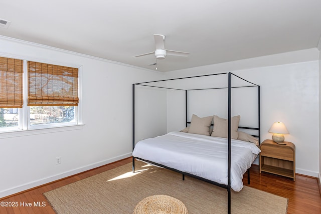 bedroom with visible vents, baseboards, and wood finished floors