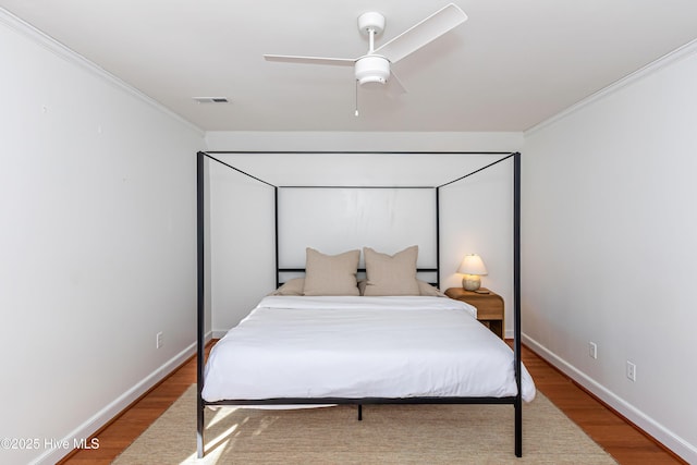 bedroom featuring crown molding, visible vents, and light wood-type flooring