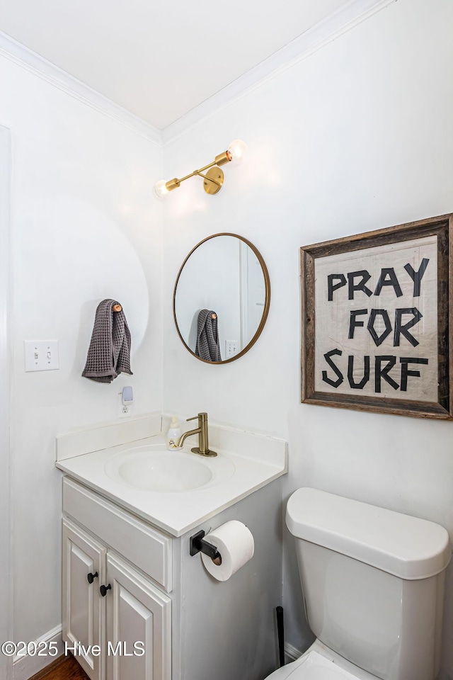bathroom featuring vanity, toilet, and crown molding