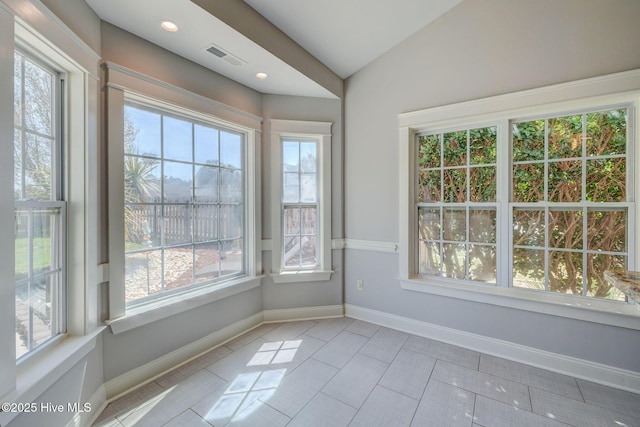 spare room with plenty of natural light and baseboards