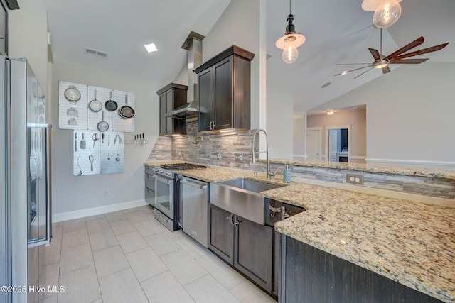 kitchen featuring wall chimney range hood, a sink, ceiling fan, stainless steel appliances, and backsplash