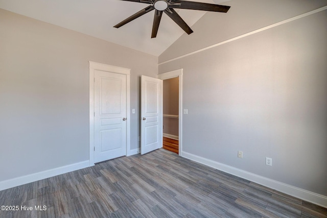 empty room featuring dark wood-type flooring, high vaulted ceiling, baseboards, and ceiling fan