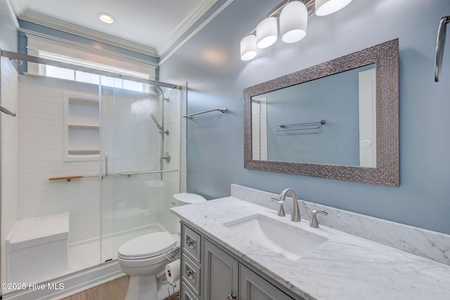 bathroom featuring toilet, crown molding, wood finished floors, and a stall shower