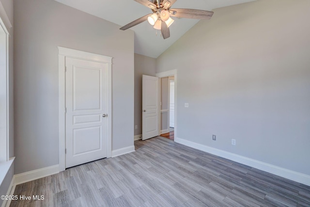 unfurnished bedroom with vaulted ceiling, wood finished floors, baseboards, and ceiling fan