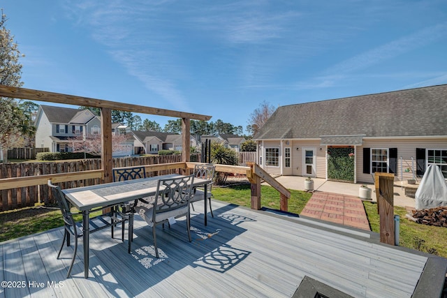 wooden terrace with a residential view, outdoor dining space, and fence