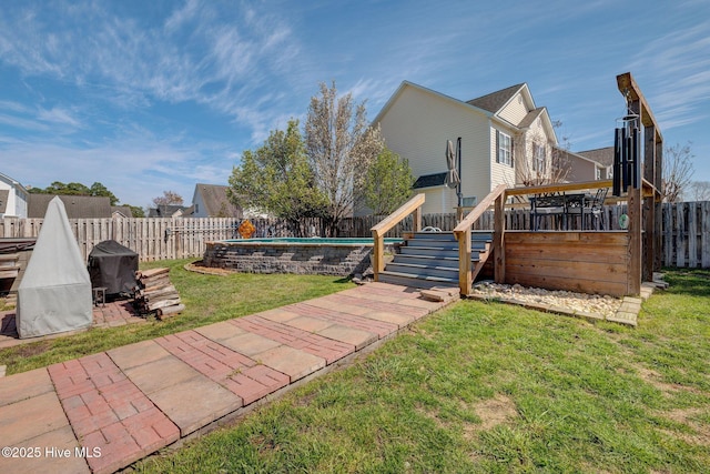 view of yard featuring a fenced backyard, a wooden deck, stairway, and a fenced in pool