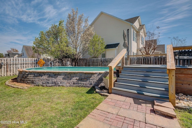 view of yard with a fenced backyard, a deck, and a fenced in pool