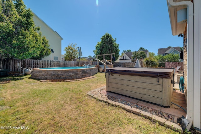 view of yard featuring a fenced in pool, a hot tub, and a fenced backyard