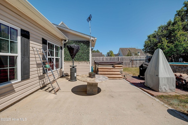 view of patio featuring fence and a hot tub