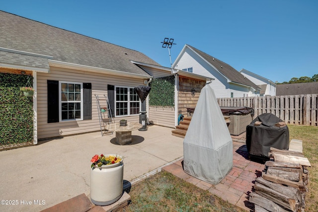 view of patio featuring a grill and fence