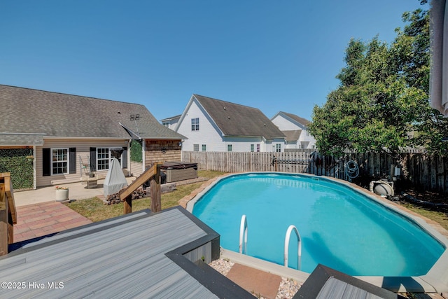 view of pool featuring a residential view, a fenced in pool, a fenced backyard, a hot tub, and a patio