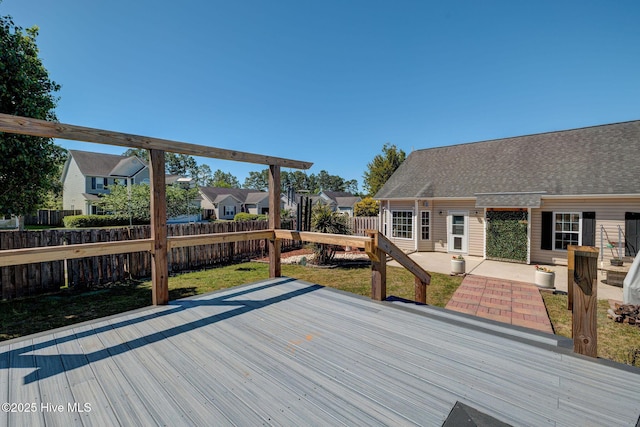 deck with a fenced backyard, a residential view, a yard, and a patio