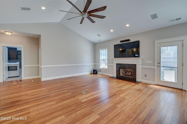 unfurnished living room with lofted ceiling, visible vents, light wood-type flooring, and ceiling fan