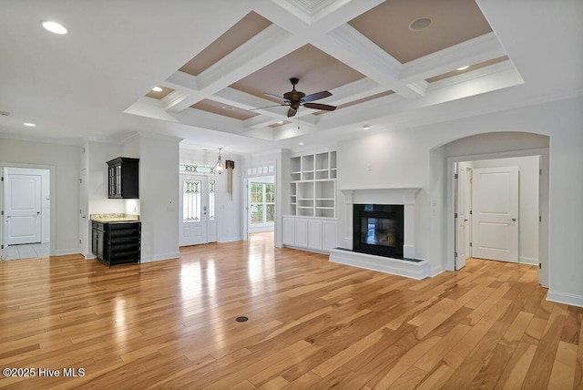 unfurnished living room featuring light wood-type flooring, ceiling fan, baseboards, and a glass covered fireplace