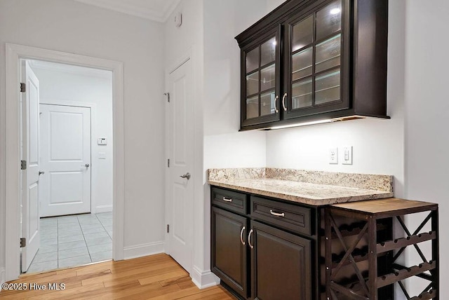 bar featuring light wood-type flooring and baseboards