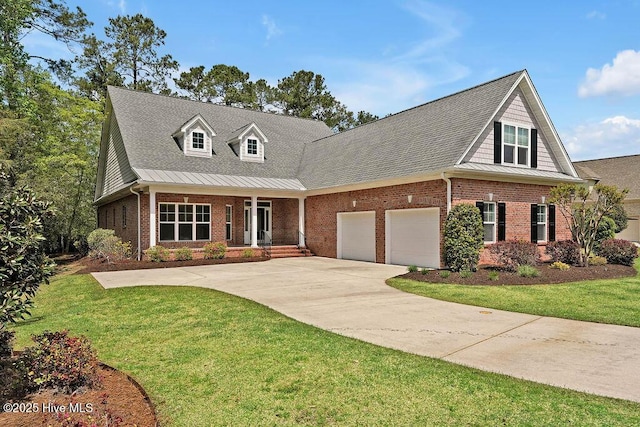 view of front of house featuring brick siding, a front yard, driveway, and a garage