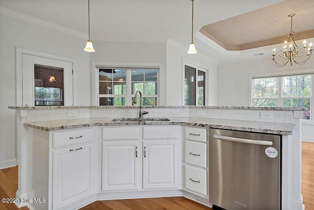 kitchen featuring an inviting chandelier, crown molding, light wood-style floors, stainless steel dishwasher, and a sink