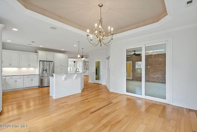 kitchen with ceiling fan with notable chandelier, stainless steel fridge with ice dispenser, light wood-style flooring, white cabinets, and visible vents