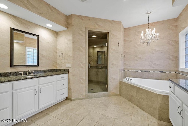 full bathroom featuring a bath, an inviting chandelier, a shower stall, vanity, and tile patterned floors