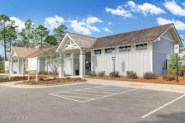 view of building exterior featuring uncovered parking and fence