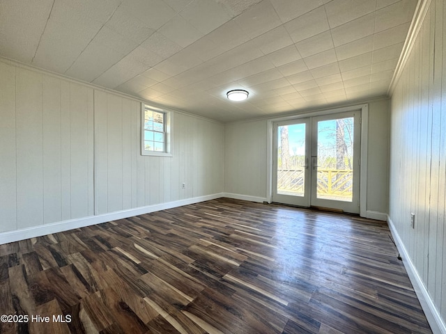 1309 Gaston Sellers Rd, Whiteville, NC 28472 - empty room featuring dark wood finished floors, french doors, ornamental molding, baseboards, and wooden walls