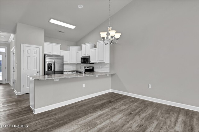 5006 Carleton Dr Unit 141, Wilmington, NC 28403 - kitchen featuring stainless steel appliances, a peninsula, white cabinets, tasteful backsplash, and dark wood-type flooring