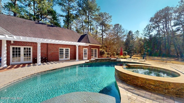view of pool featuring french doors, a pool with connected hot tub, and a patio