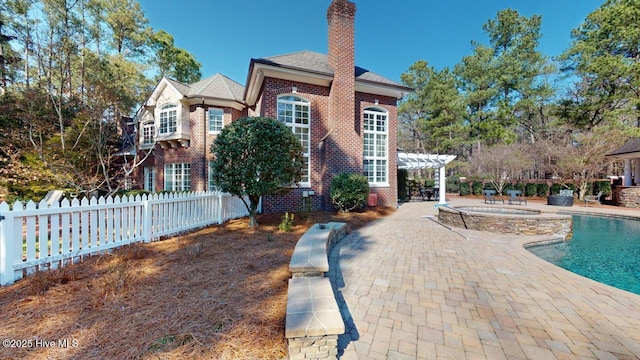 exterior space with a pergola, a patio, fence, a fenced in pool, and an in ground hot tub