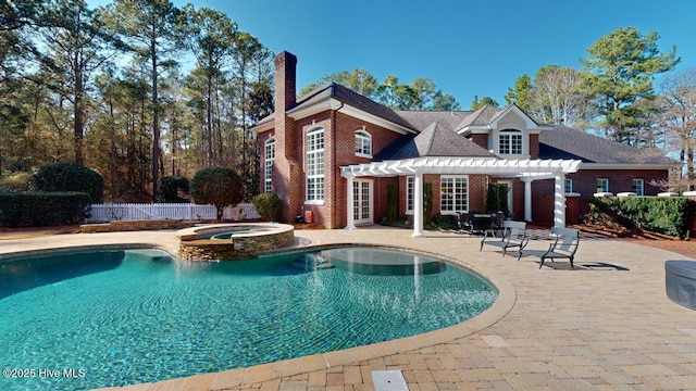 view of swimming pool with a patio area, a pool with connected hot tub, a pergola, and fence