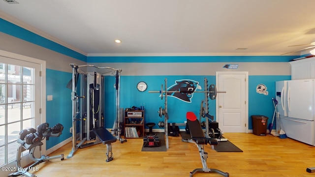 workout room with visible vents, baseboards, ornamental molding, and light wood finished floors