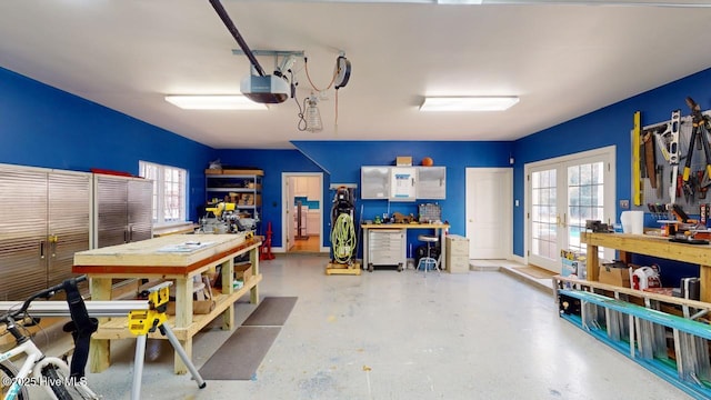 garage with a workshop area, a garage door opener, and french doors