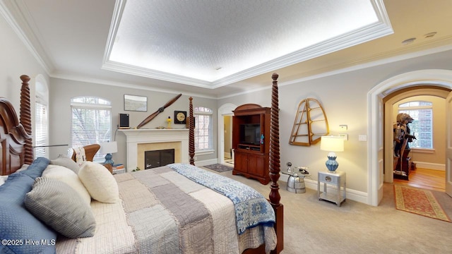 bedroom with light colored carpet, a fireplace, baseboards, and ornamental molding