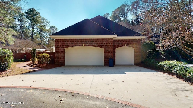 view of home's exterior with concrete driveway, a garage, and brick siding