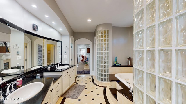 bathroom with a bath, recessed lighting, tile patterned floors, and vanity
