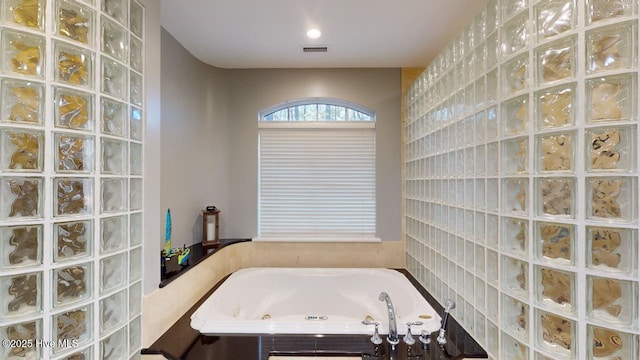 bathroom with a jetted tub, visible vents, and walk in shower