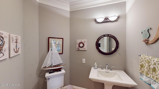 half bathroom with crown molding and toilet