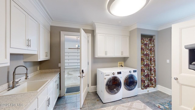 washroom with washer and dryer, ornamental molding, cabinet space, and a sink