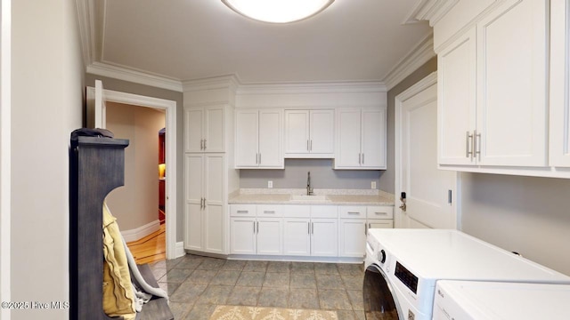 kitchen featuring a sink, independent washer and dryer, white cabinets, and light countertops
