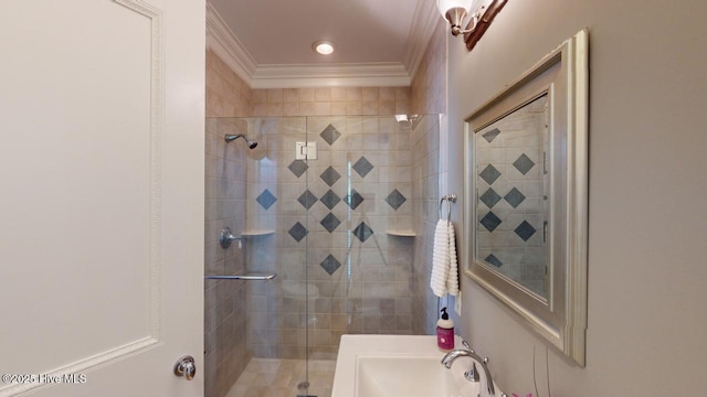 full bath featuring crown molding, a stall shower, and a sink