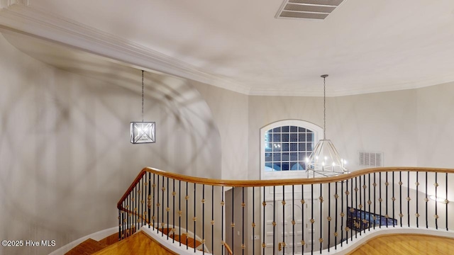 staircase with crown molding, a notable chandelier, visible vents, and baseboards