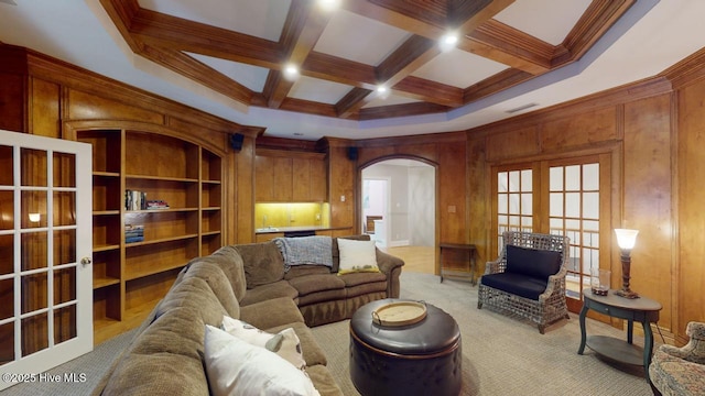 living area with french doors, arched walkways, coffered ceiling, and beam ceiling