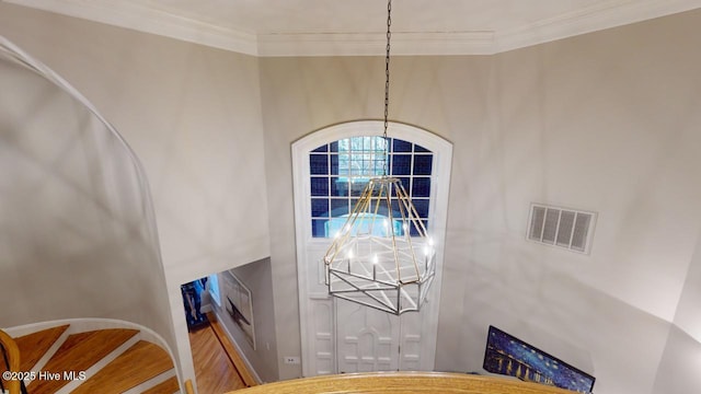 interior details with a chandelier, visible vents, baseboards, and ornamental molding