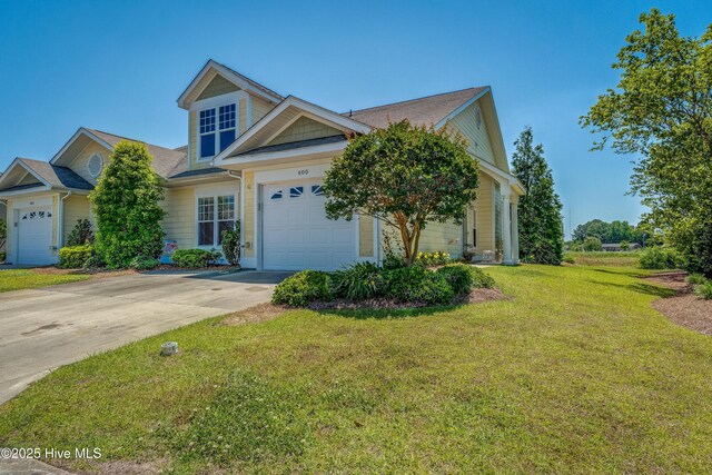 view of front of property with a garage, a front lawn, and driveway