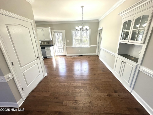 8107 Gentle Breeze Dr, Sims, NC 27880 - unfurnished dining area featuring dark wood-type flooring, baseboards, crown molding, and an inviting chandelier